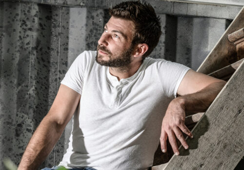 L'artiste Antoine Dufilho qui pose sur les marches de son atelier.