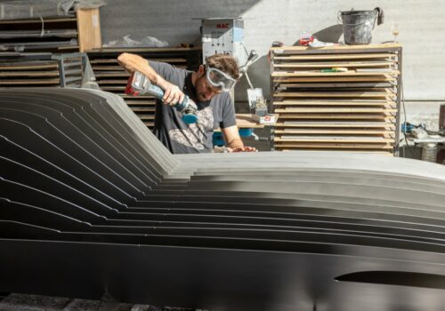 Antoine Dufilho travaillant dans son atelier sur une sculpture automobile en plaques métalliques